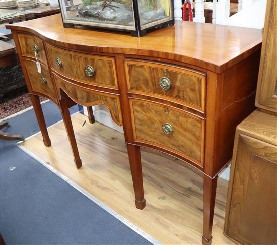 An Edwardian satinwood serpentine fronted mahogany sideboard, with tubular brass railed back W.152cm